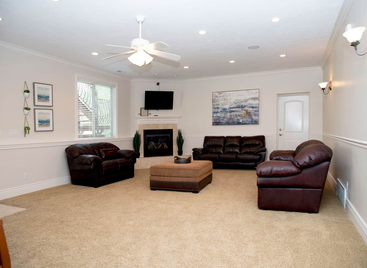 Bright living room with leather sofas, fireplace, and TV.