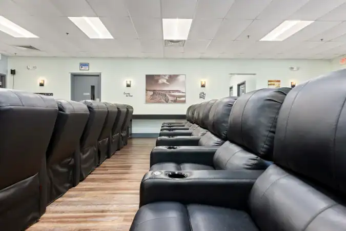Rows of black recliners in a spacious group lounge