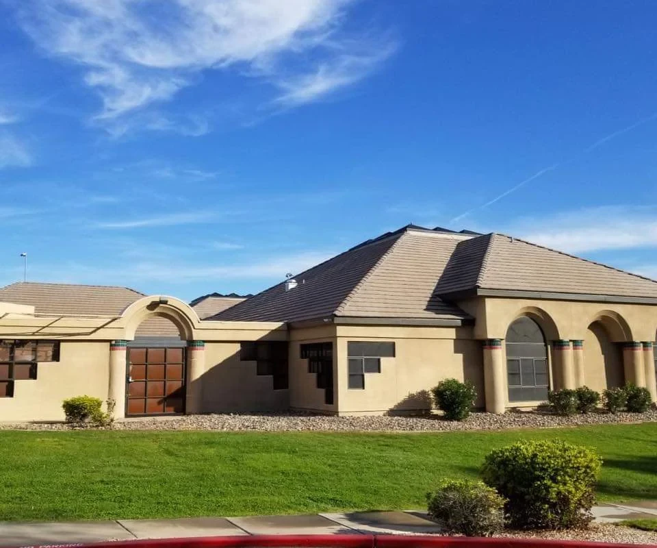 Beige rehab facility with arched windows and manicured lawn