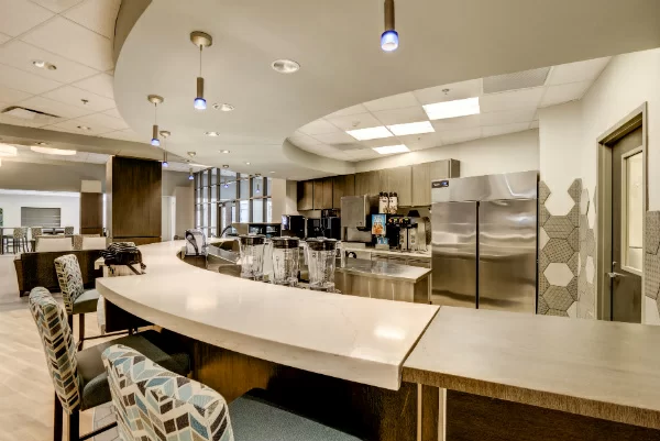 Stainless steel kitchen with bar seating and modern lighting