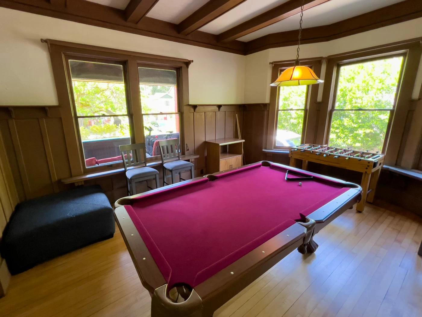 Game room with pool table and foosball by windows