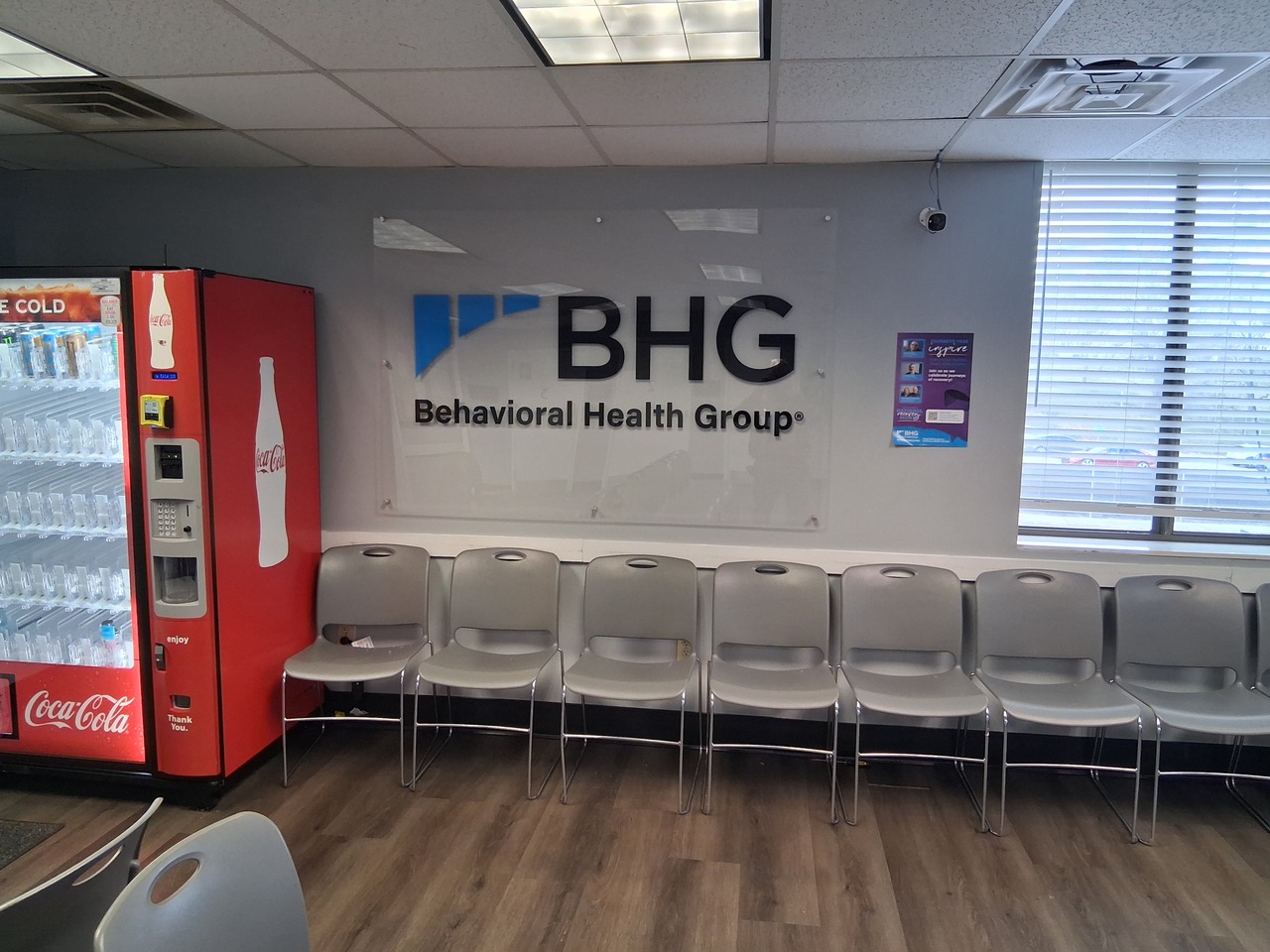Waiting area with chairs, beverage machine, and BHG wall sign