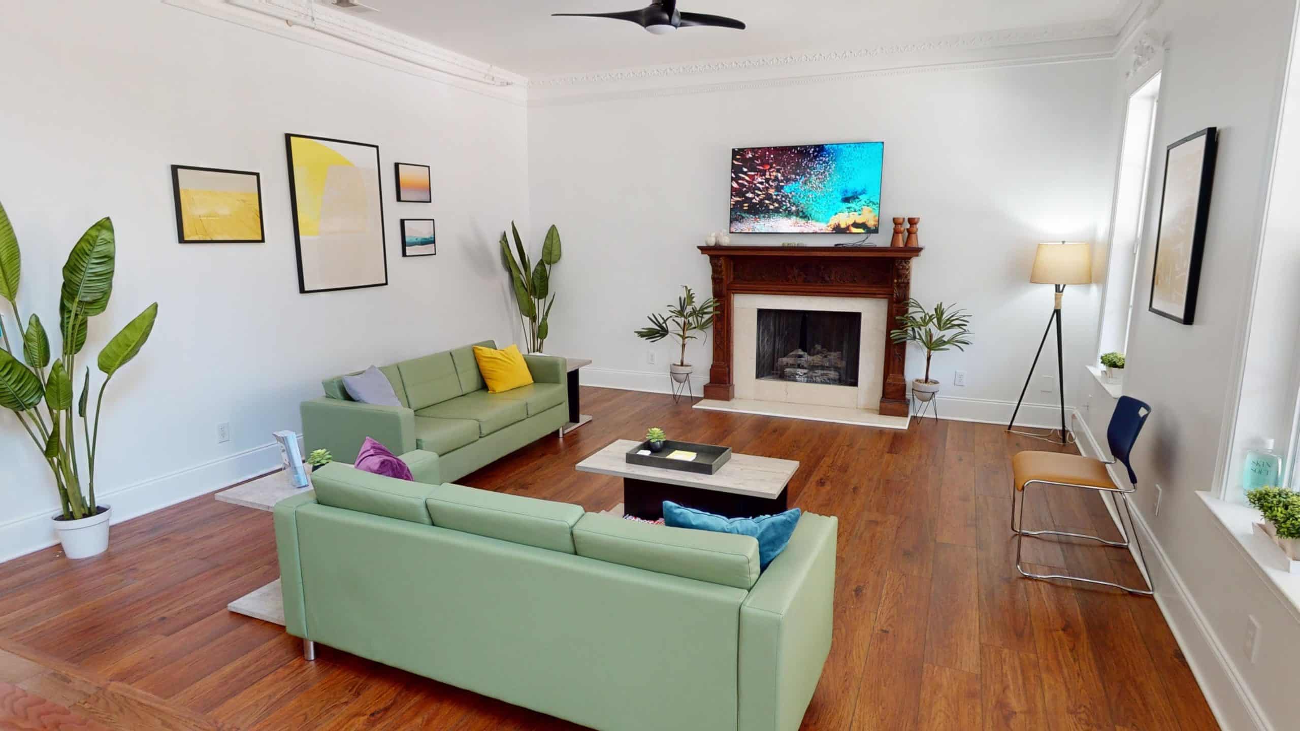 Common area with green sofas and fireplace