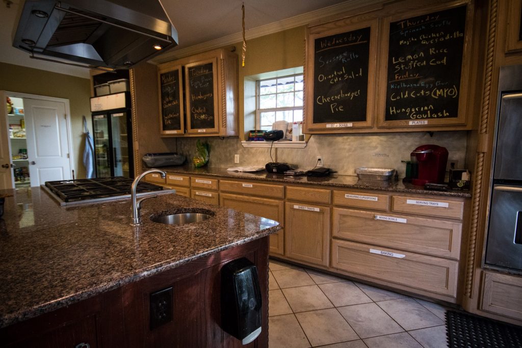 Kitchen with menu boards and granite counters