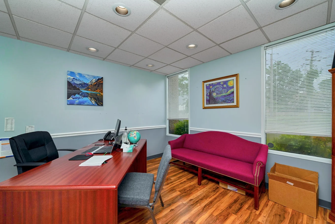 Private counseling office with desk and sofa seating
