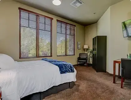 Private resident bedroom with desk and TV