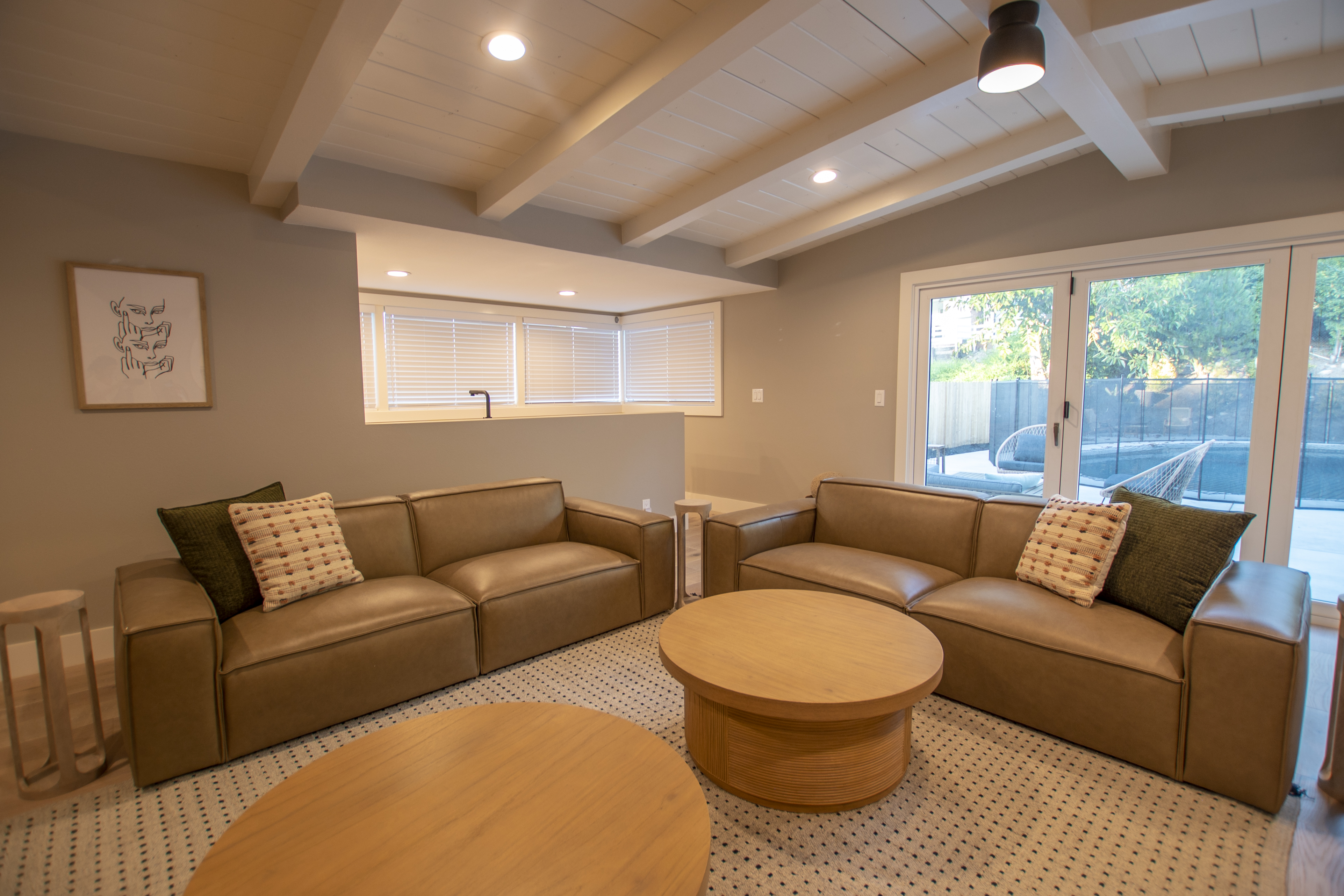 Lounge with leather couches and view of fenced-in pool