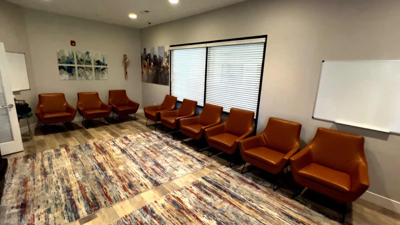 Group therapy room with chairs and whiteboards at Brighton House