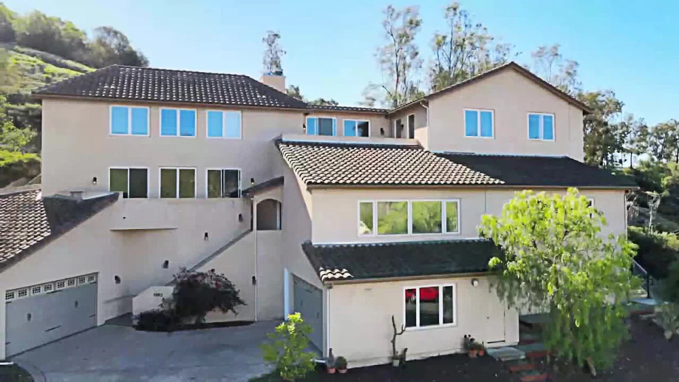 Large beige multi-story rehab facility with hillside views