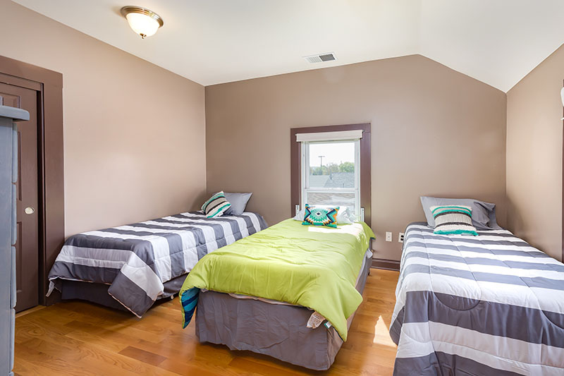 Shared bedroom with three single beds and natural light