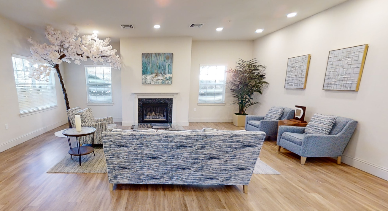 Lounge with blue seating, fireplace, and artwork
