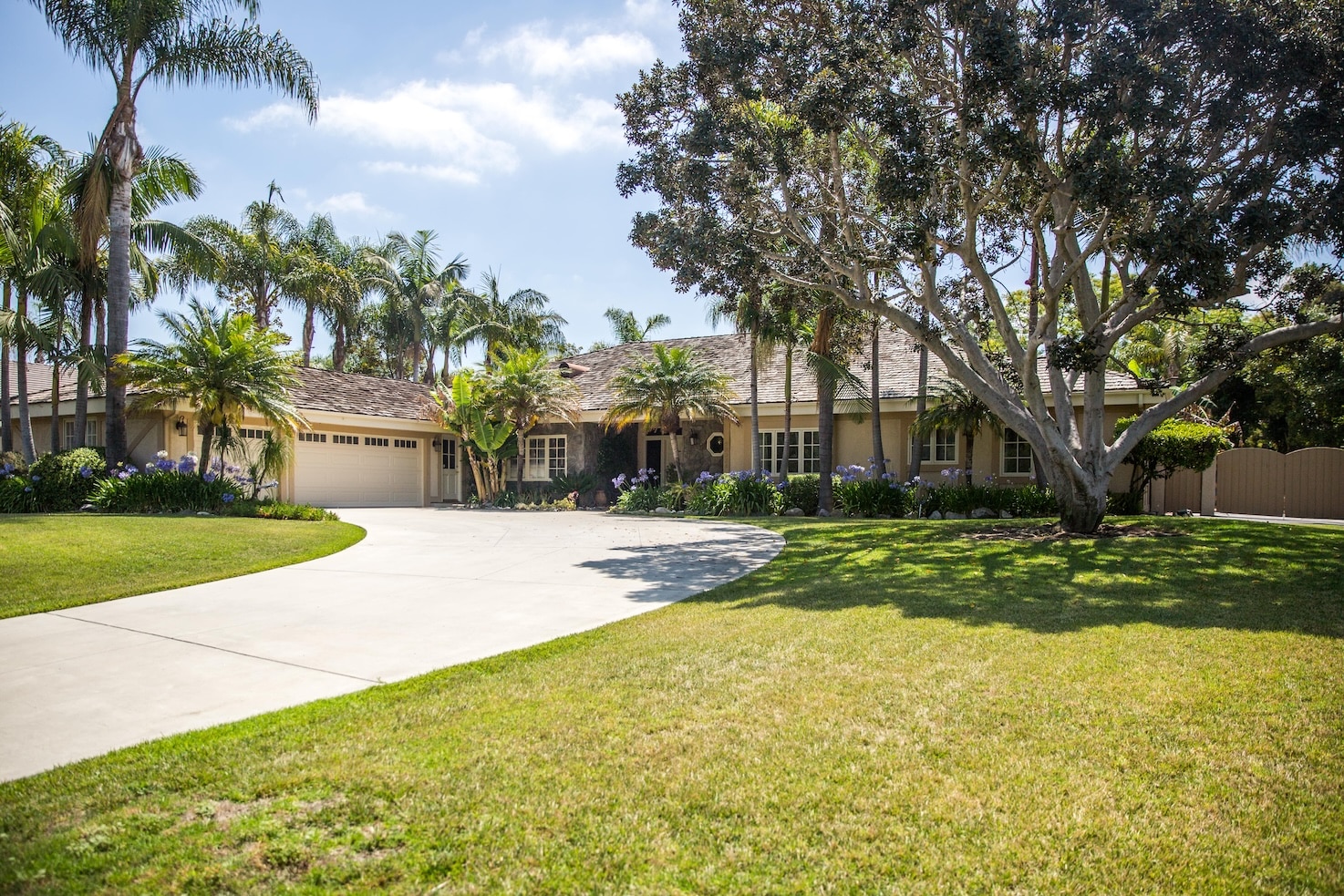 A rehab center with a lush front yard and palm trees.