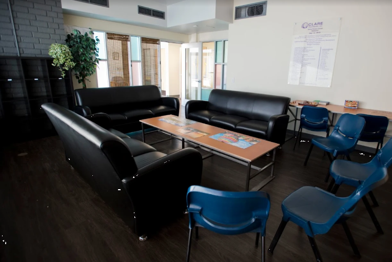 Group therapy room with black sofas and blue chairs