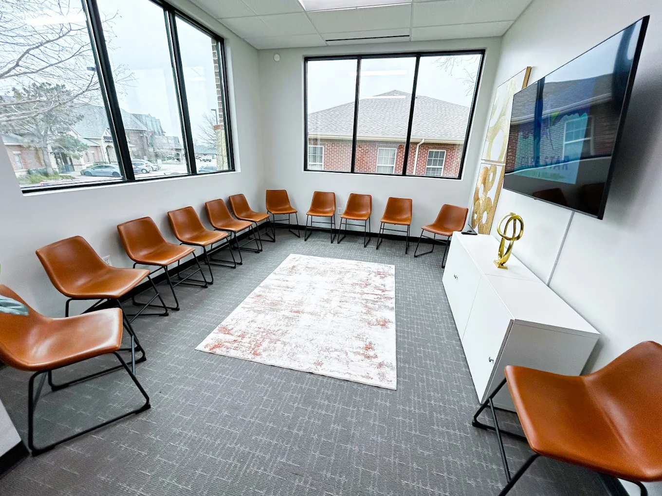 Circle of tan chairs in therapy room