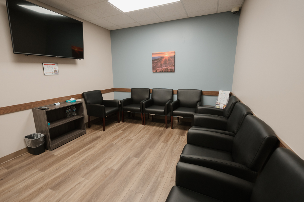 Dosing room with black armchairs and wall-mounted television
