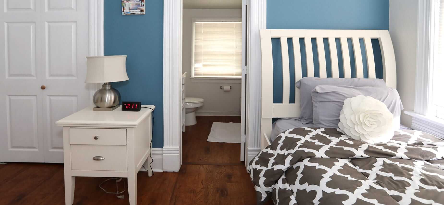Bright bedroom with white furniture and ensuite bath