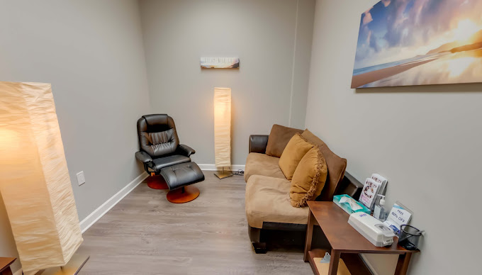 Therapy room with arranged chairs and a whiteboard for sessions.