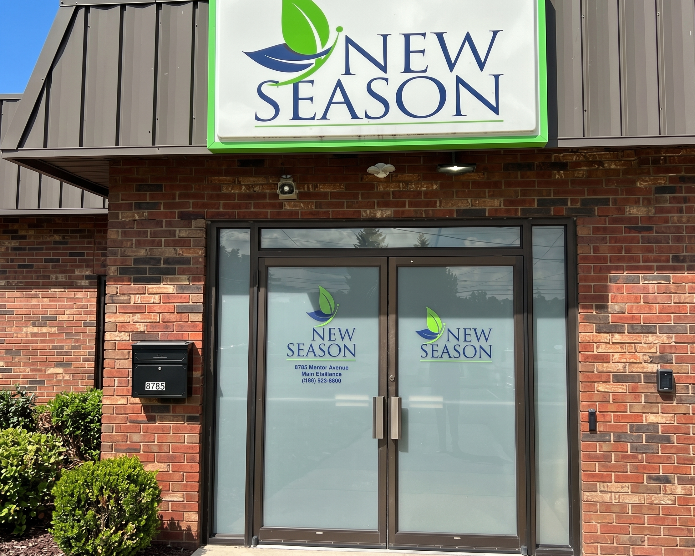 New Season glass entrance with brick exterior and facility sign