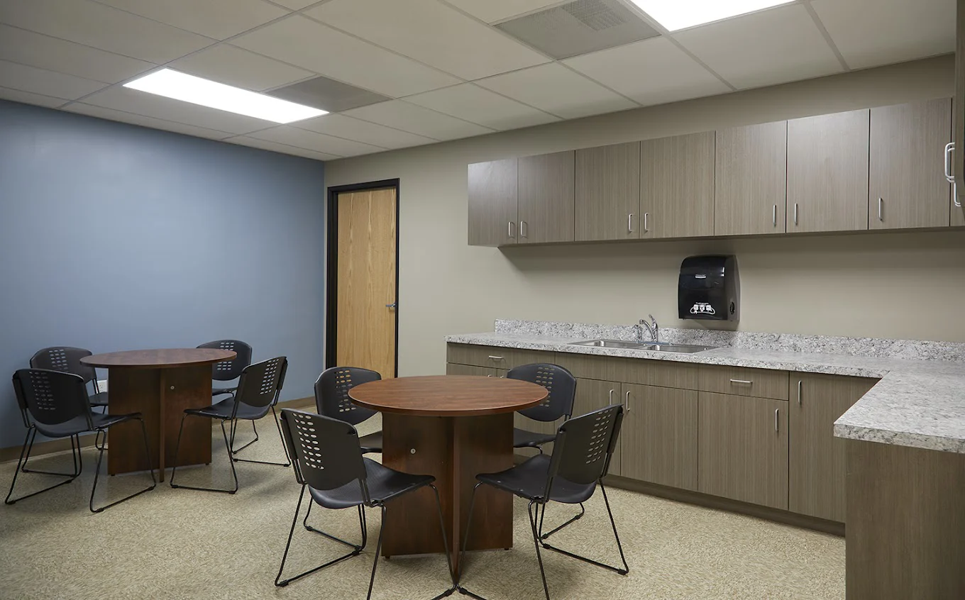Multipurpose room with tables, chairs, cabinets, and sink