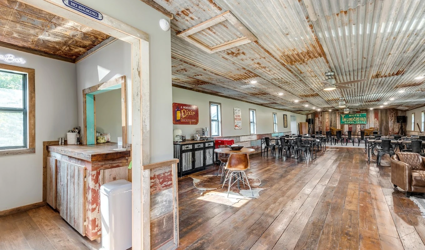 Spacious dining area with rustic metal ceiling and wooden floors
