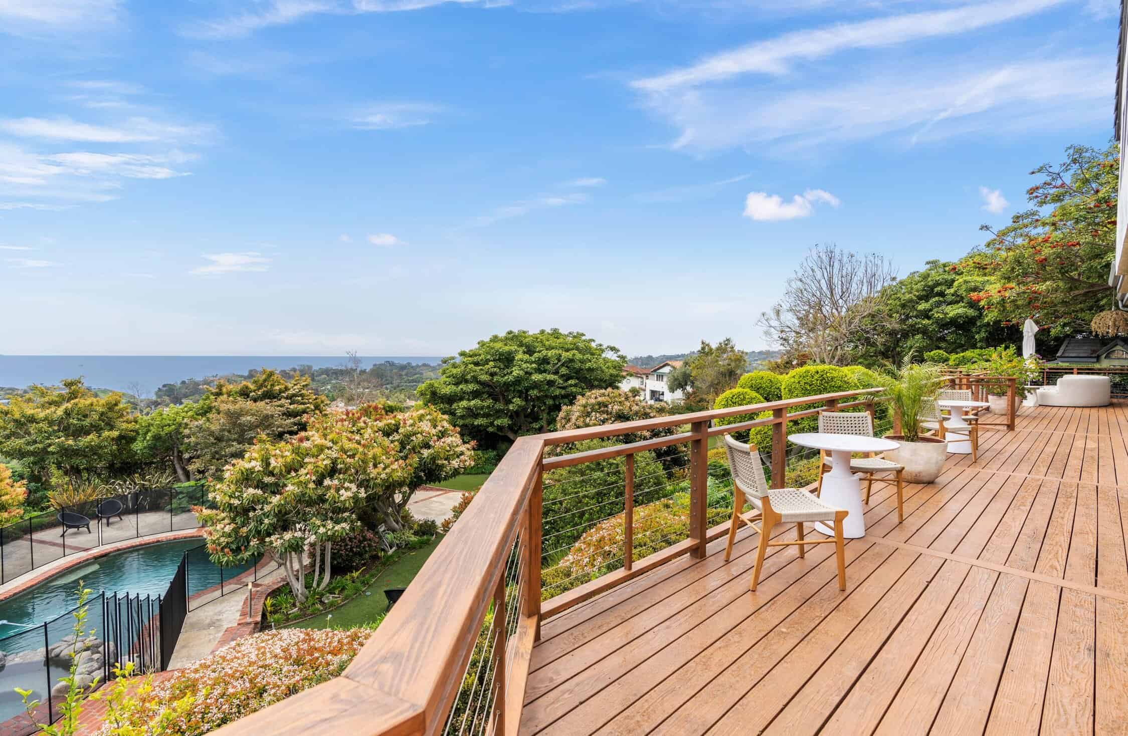 Expansive wood deck overlooking ocean and pool
