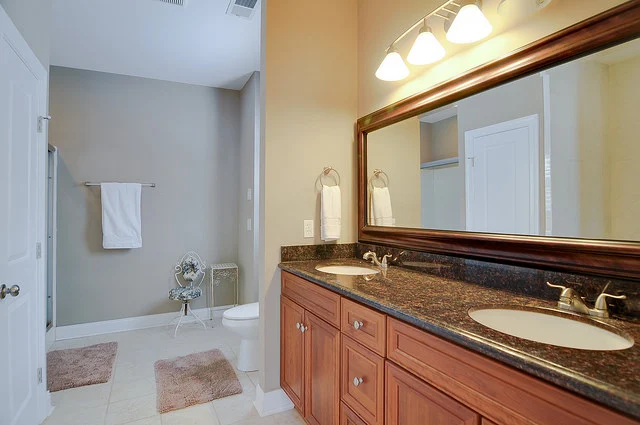 Elegant bathroom with double vanity, granite countertops, and a large mirror