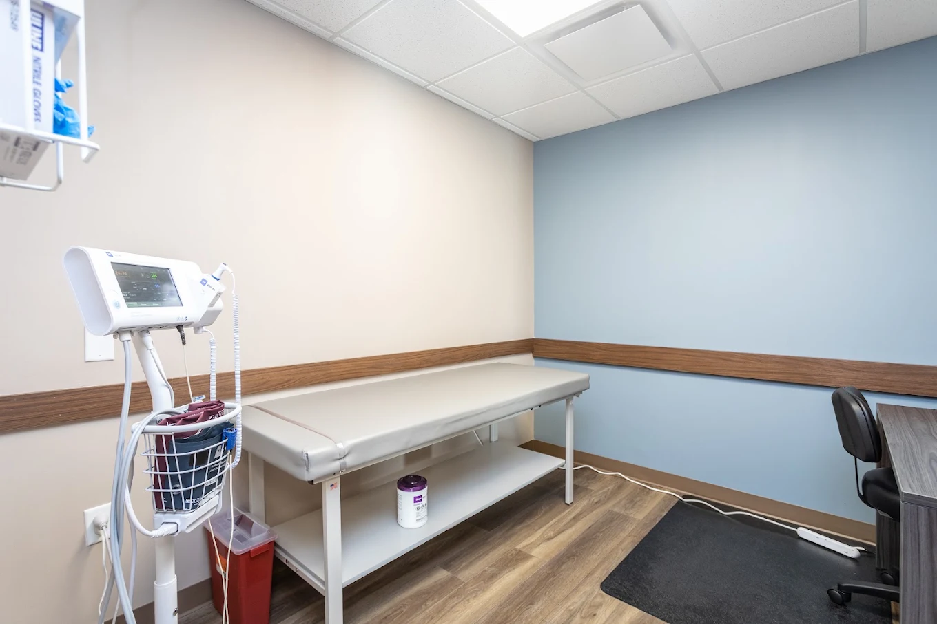 Treatment room with exam table, vital signs monitor, and clinical equipment