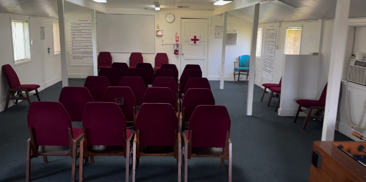 Meeting room with red chairs facing a whiteboard