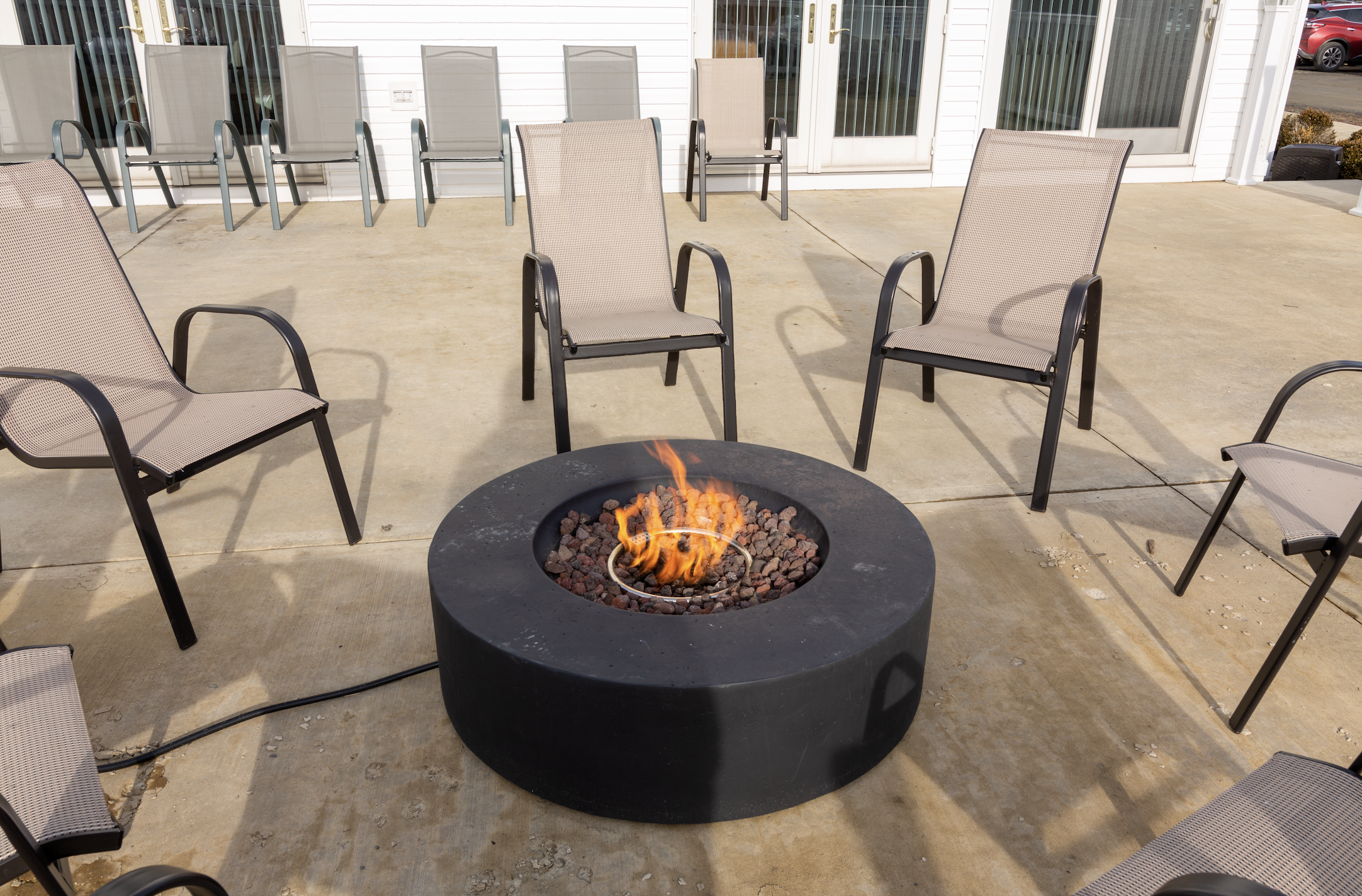 Round firepit with chairs on rehab center patio
