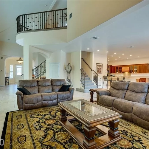 Living area with sofas, coffee table, and open kitchen
