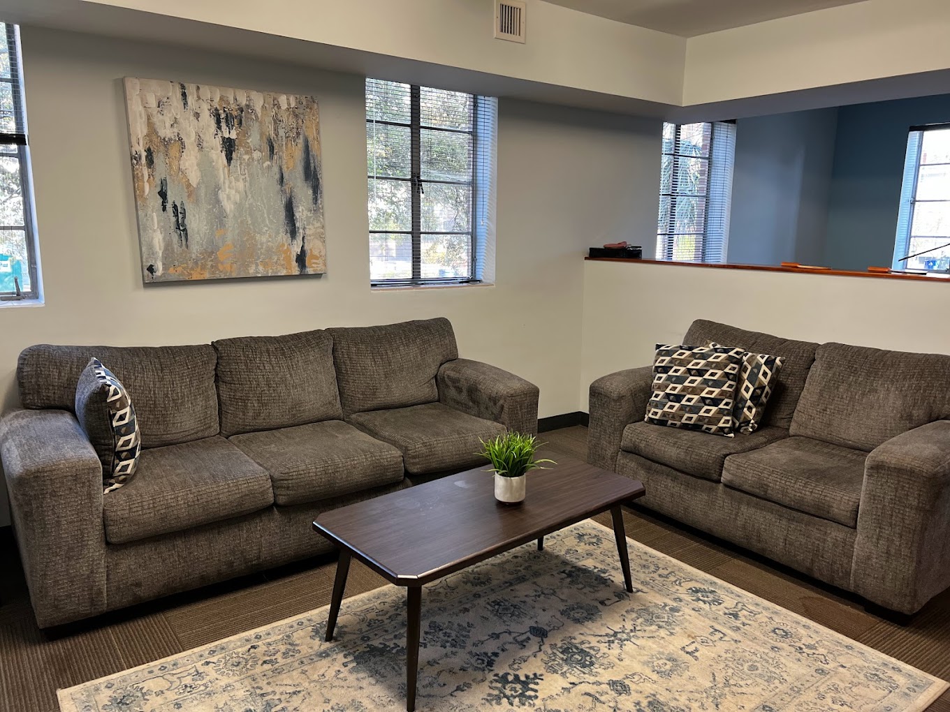 Comfortable lounge space with two gray sofas and modern decor.