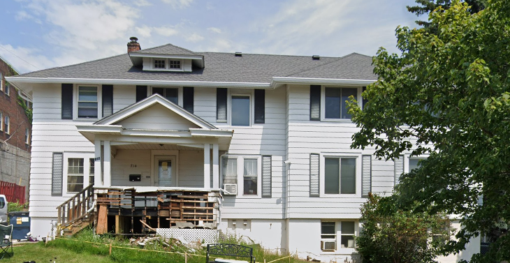 Two-story white rehab house with front porch 