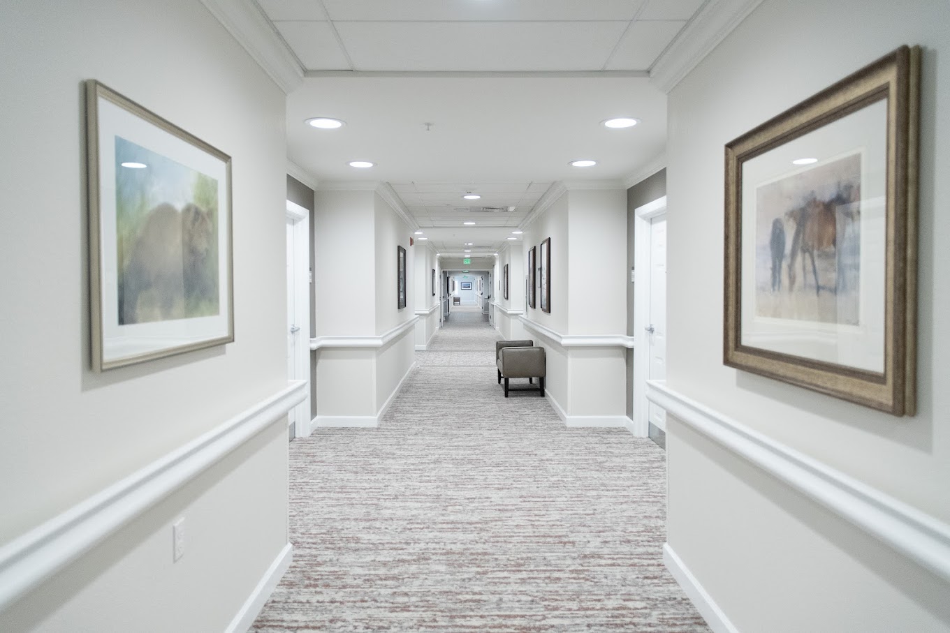 Long hallway with framed art and neutral decor