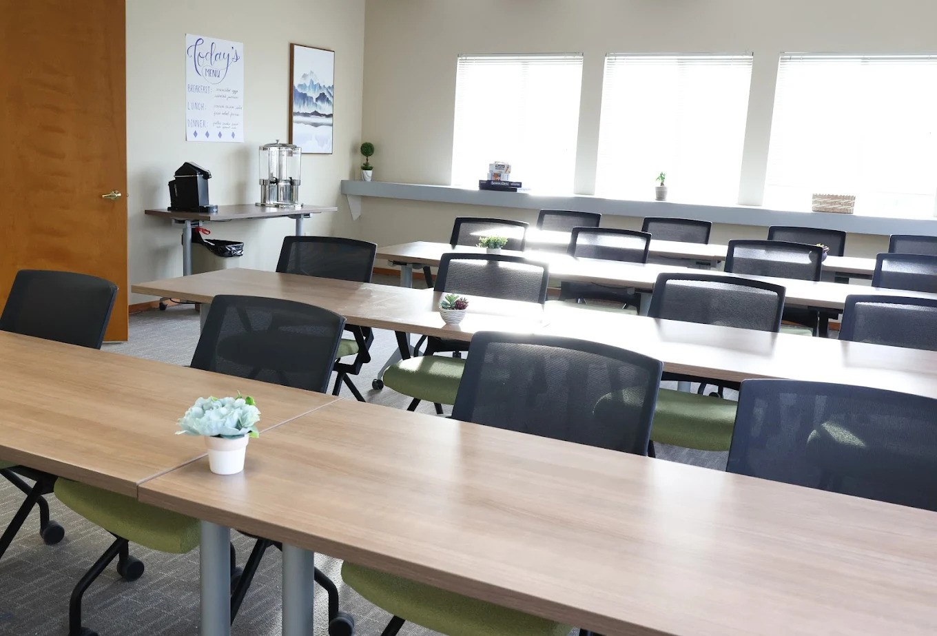 Bright meeting room with rows of chairs and wood tables