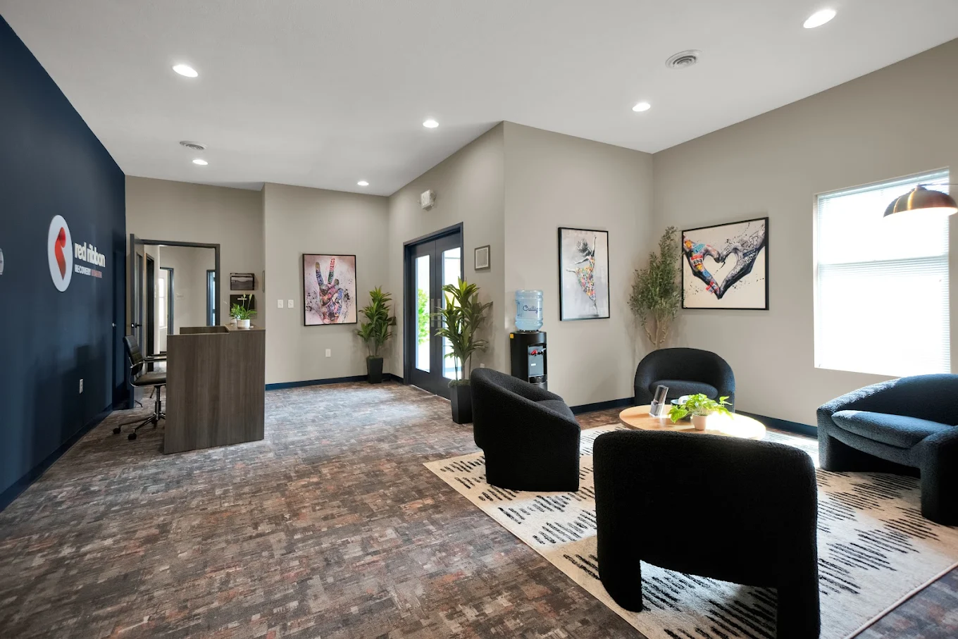 Client lounge with chairs, artwork, and natural light