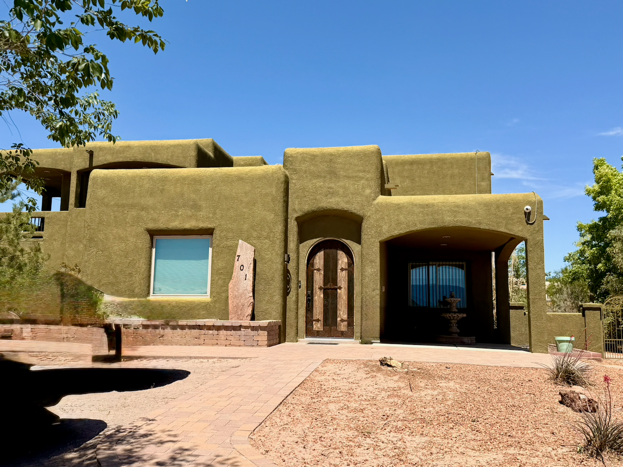 Exterior of a Southwestern-style residential treatment facility with stucco walls and desert landscaping in Albuquerque