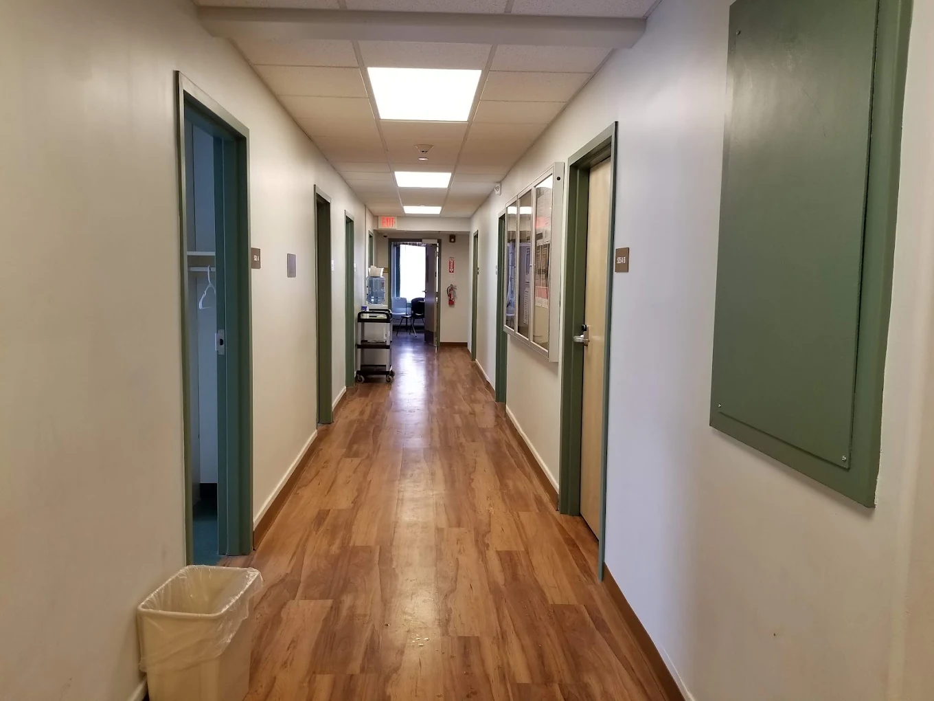 Facility hallway with wood flooring and doors on both sides