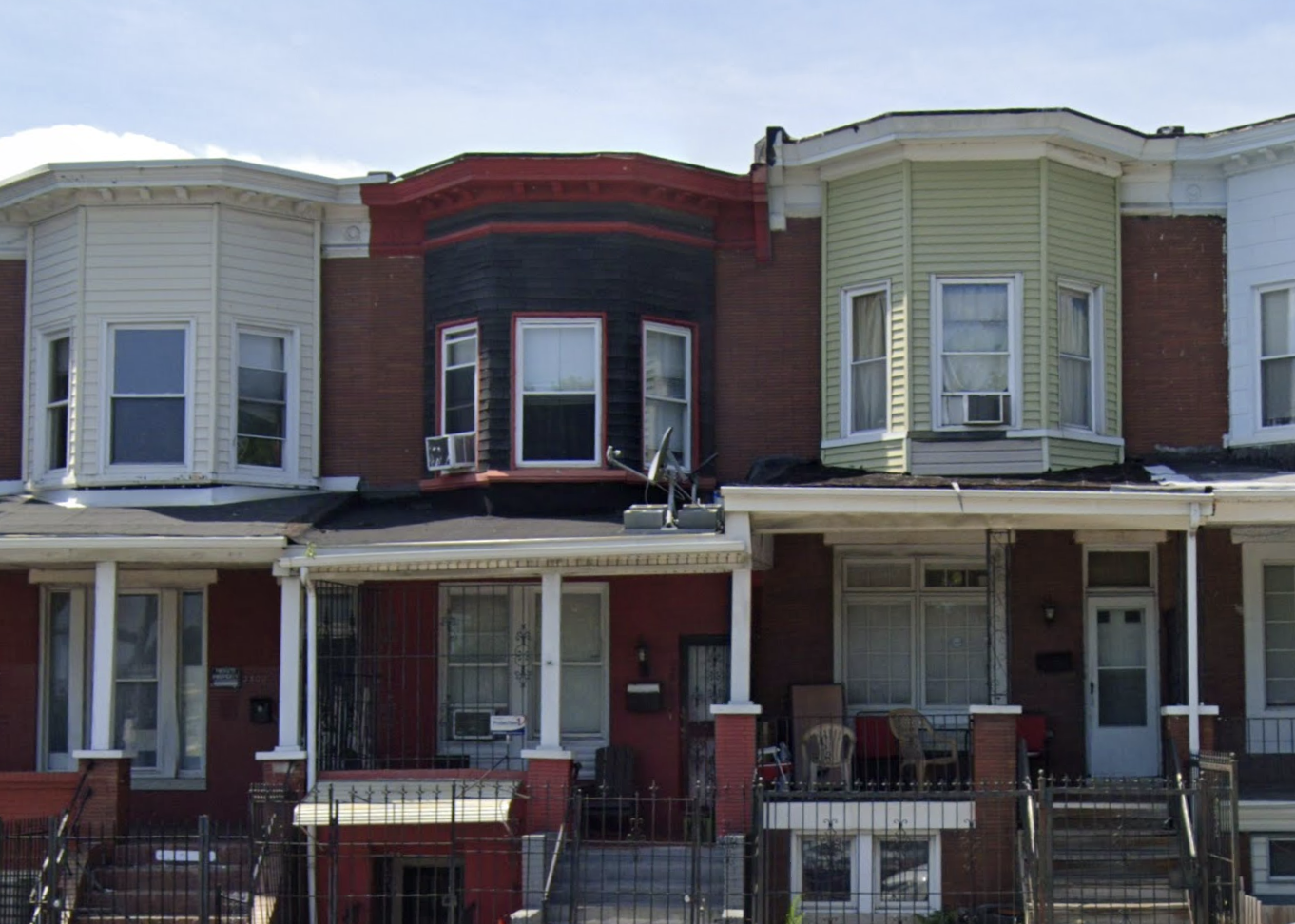 A welcoming building with a large lawn, trees, and a pergola at the entrance, creating a serene atmosphere.