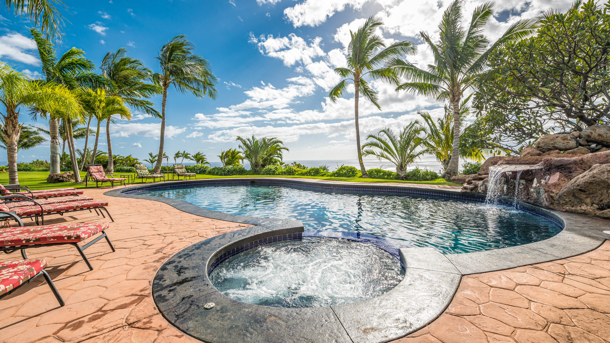 Outdoor swimming pool and spa with panoramic ocean views and tropical landscaping
