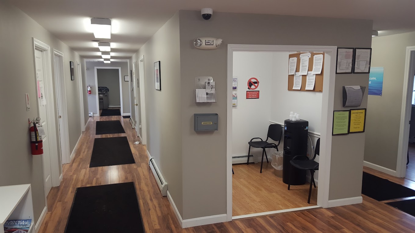 Hallway to offices with waiting room with chairs.