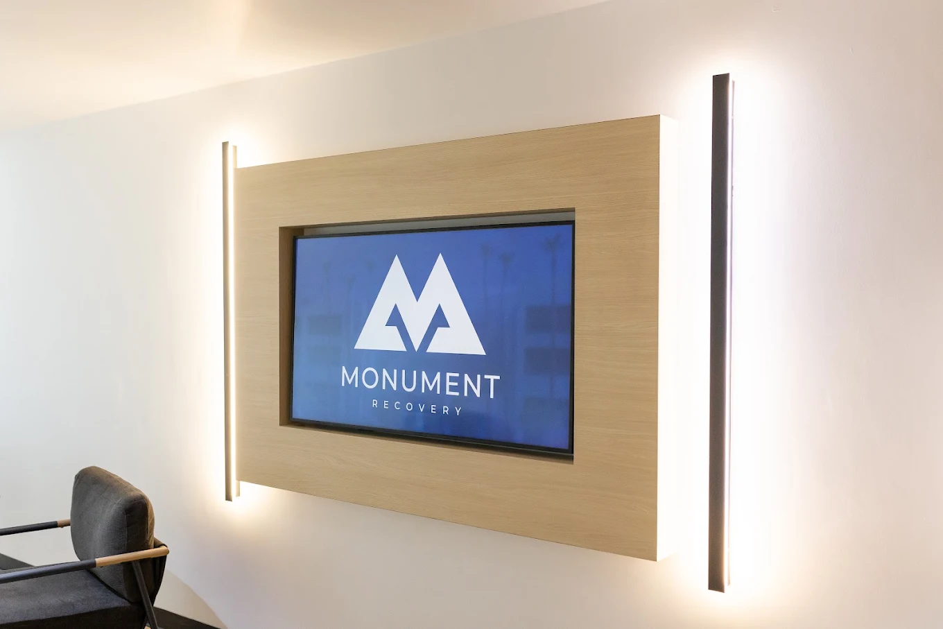 Illuminated Monument Recovery sign mounted on interior wall