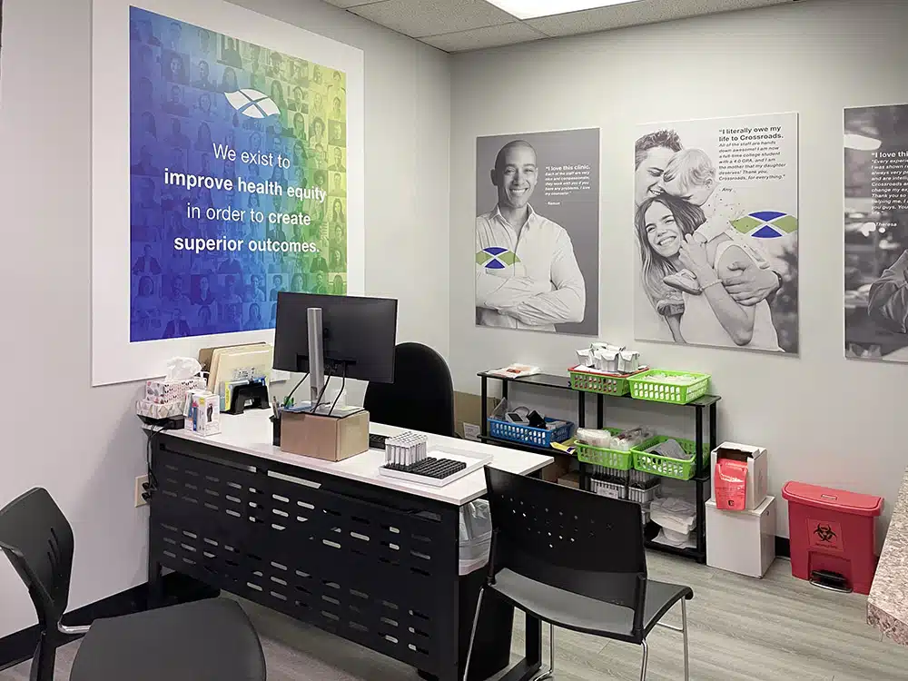 Intake office with desk, chairs, and health equity wall sign