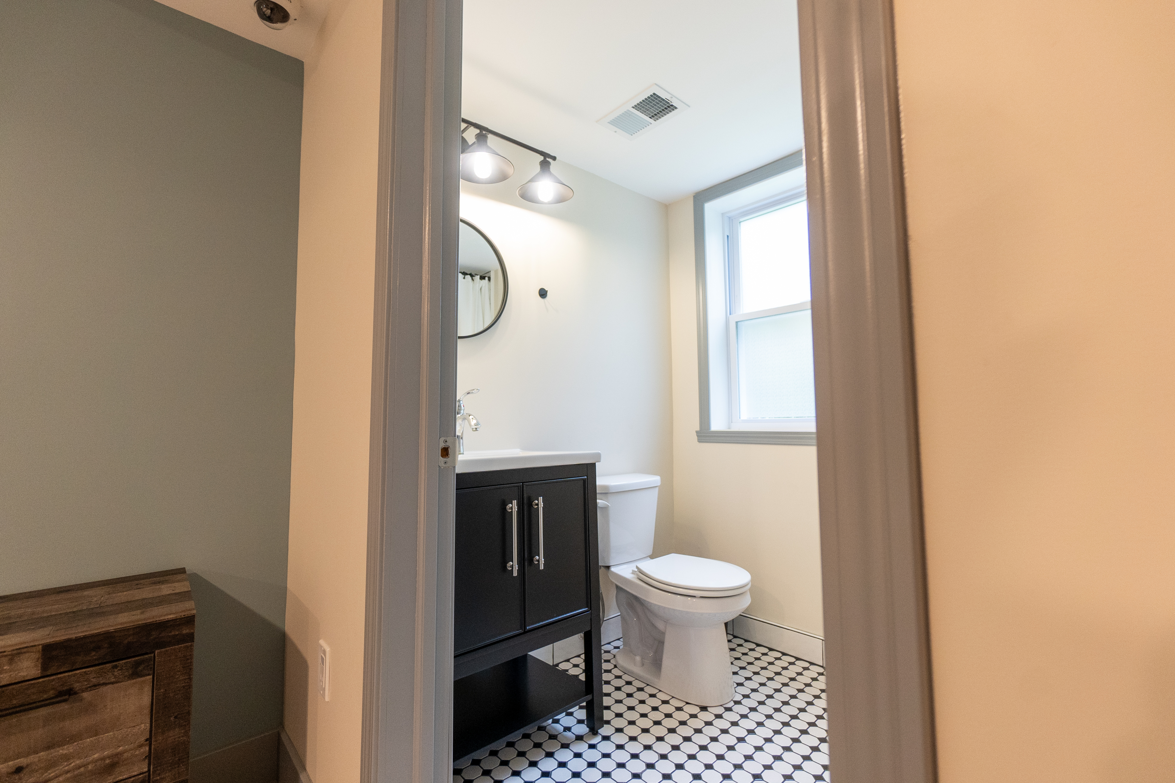 Clean bathroom with vanity, mirror, and window.