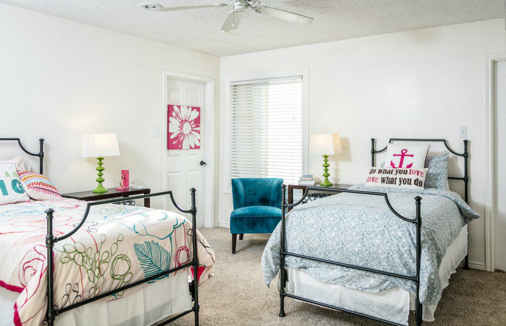 Shared bedroom with two beds and bedside lighting