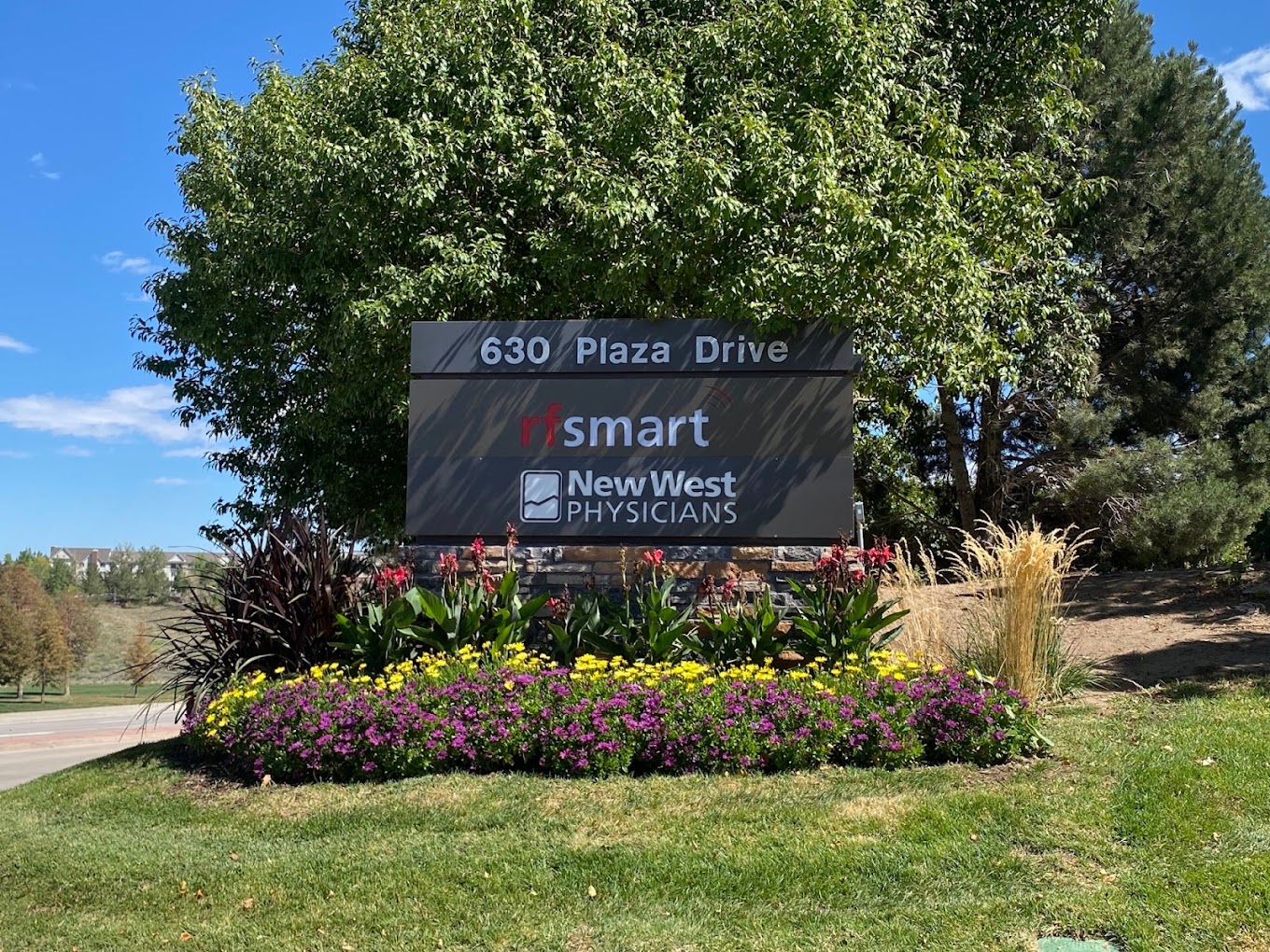 Outdoor sign for a medical office surrounded by greenery.
