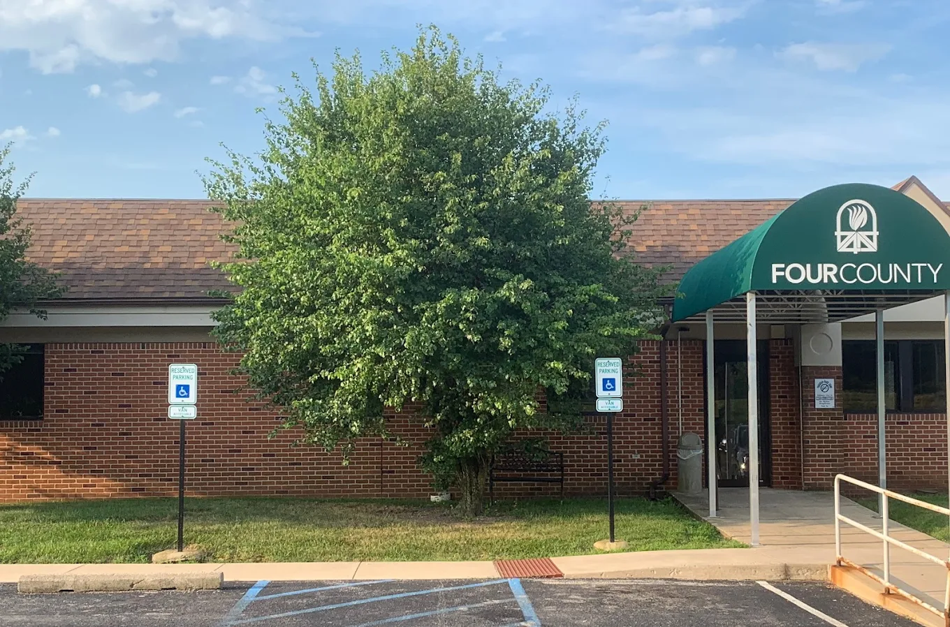 Exterior entrance of 4C Health’s Miami County Satellite office in Peru, Indiana, featuring a brick building with green awning and handicap parking signs