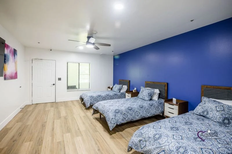 Shared bedroom with three beds and television