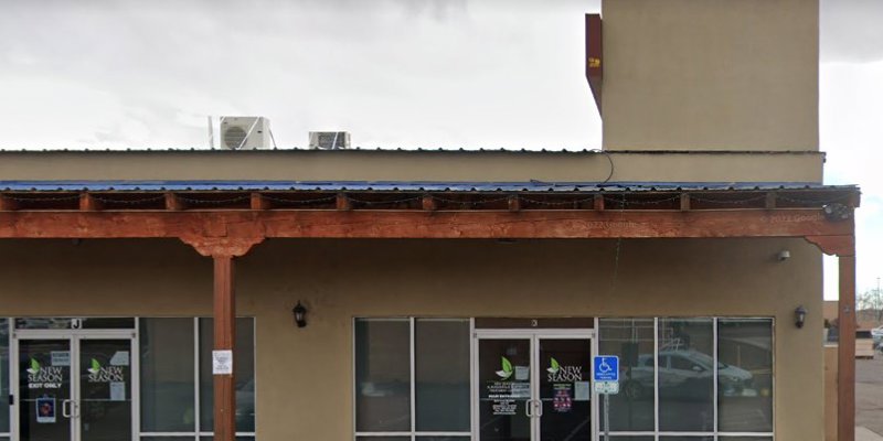 Front of a clean, modern building with large windows, a covered entryway supported by wooden beams, and clear signage promoting a treatment center.