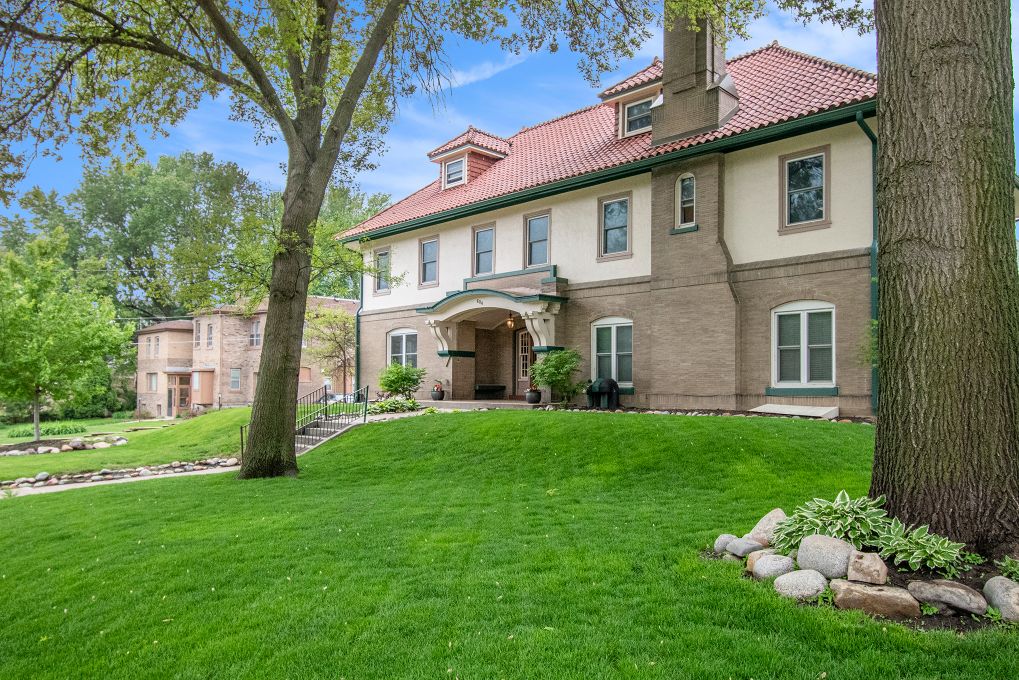 Large residential building with green lawn and mature trees