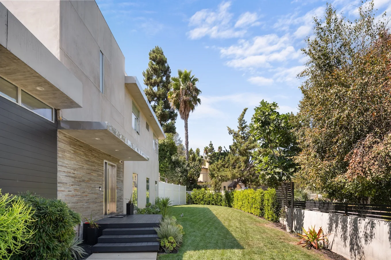 Lush garden with trees beside modern building exterior